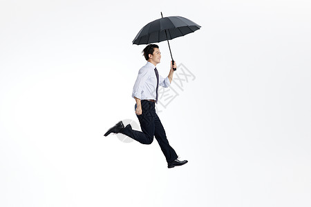 跳跃的白领男性撑雨伞图片