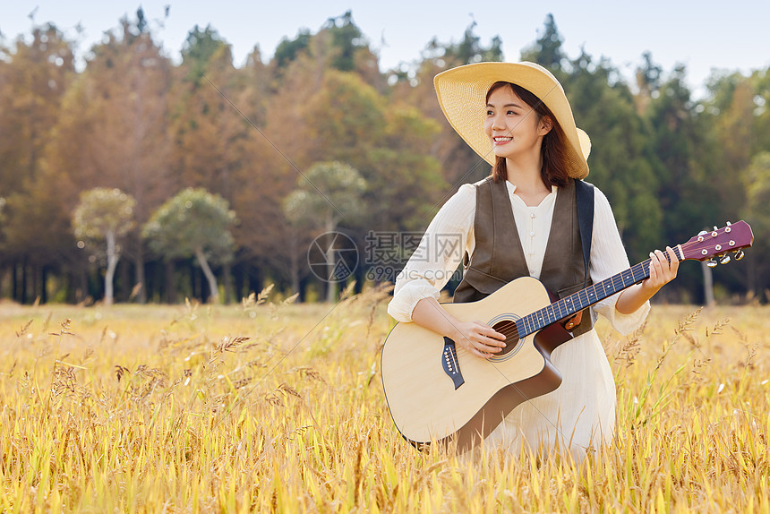 站在稻田里弹吉他的美女图片