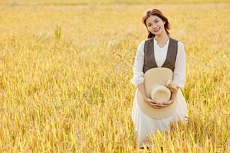 河边漫步在稻田里郊游休闲的女性背景