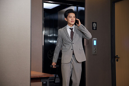 走出酒店电梯的商务男士形象图片