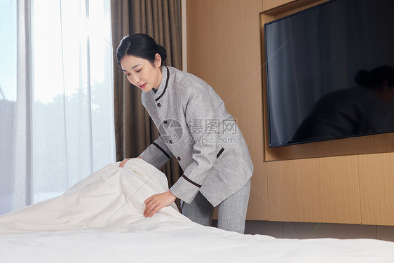 酒店服务员整理客房床铺形象图片