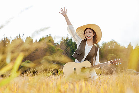 秋季稻田美女手拿吉他图片