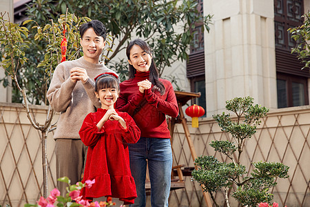 一家三口在院子里拜新年背景图片