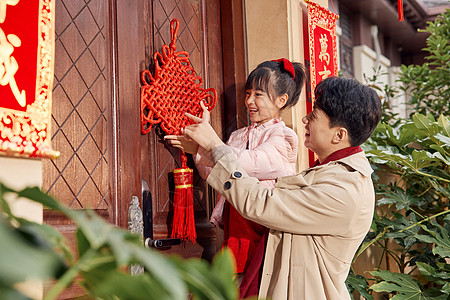 新年门口爸爸和女儿在门口装饰中国结背景