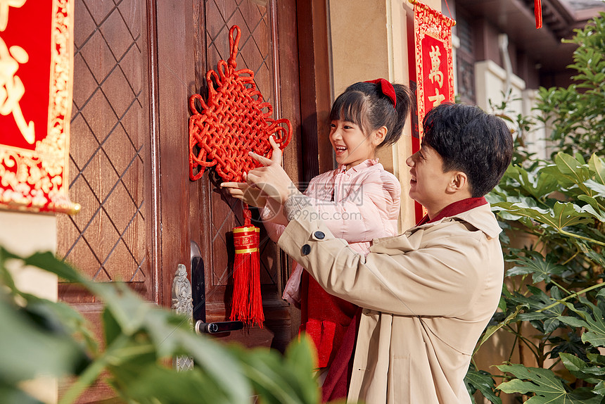 爸爸和女儿在门口装饰中国结图片
