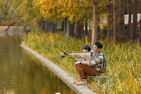 在公园湖边垂钓的父子背景