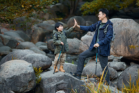 登山徒步探险的父子击掌图片