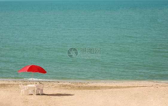 夏季海滩上带遮阳伞的桌子图片