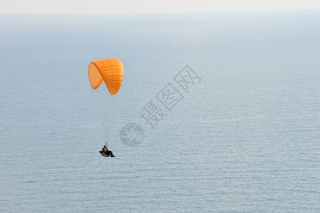 滑翔伞飞过海面图片