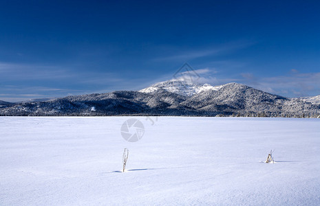 一片雪覆盖的田地在前景下宽阔蔓延背景图片