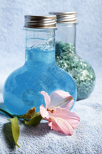 蓝色毛巾和两瓶沐浴用洗发水和盐图片