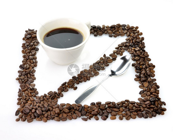 一个带勺子和咖啡豆的白咖啡杯图片