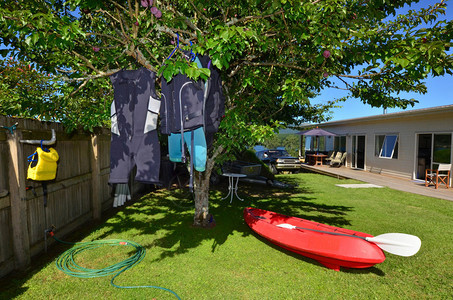红独木舟和湿衣服挂在一棵树上在独图片