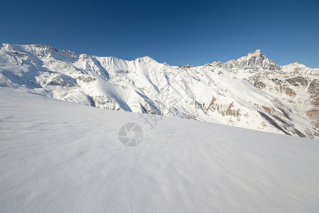 地表背景和雪坡中高山脉的全景图片