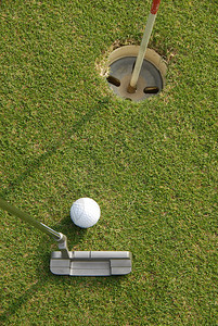 高尔夫球手把球放进洞里图片