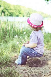 坐在河岸上体贴的小女孩图片
