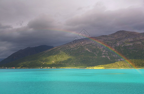 五颜六色的彩虹在水面上雷雨背景下雨图片