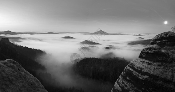 满月之夜与日出在波希米亚萨克森瑞士美丽的山砂岩山峰和小山从有雾的背景中增加第一缕阳图片