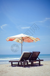沙滩上带雨伞的躺椅图片