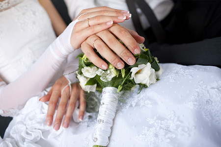 手拿着结婚戒指在花束上图片