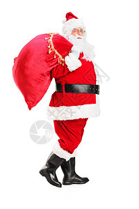 一个圣诞老人的全长肖像带着满袋礼物行走他背部被白图片