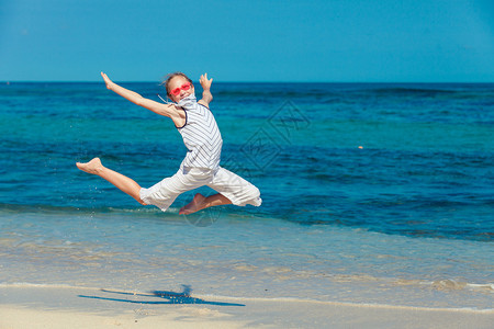 白天暑假时在蓝海滨滩上跳沙图片