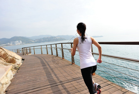 赛跑运动员在木甲板上奔跑女健身日出慢跑锻图片