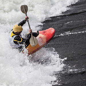 活跃的男Kayaker滚动和冲浪图片