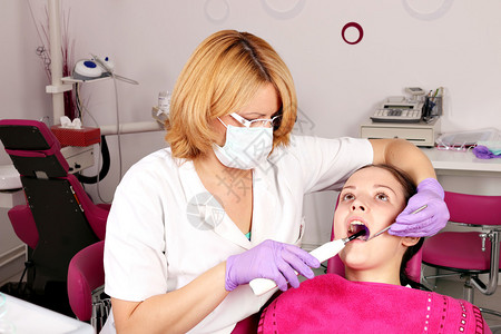 牙科诊所的女病人和牙医图片