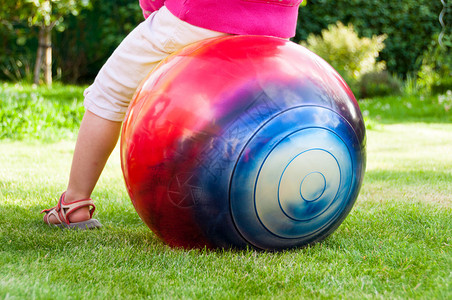 小女孩在花园里跳球图片
