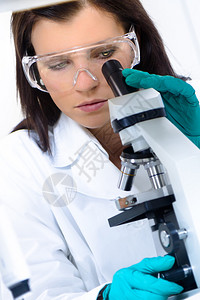 年轻有吸引力的博士生科学家看着生命科学研究实验室的显微镜幻灯片图片