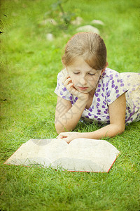 躺在草地上的公园里看书的女孩图片