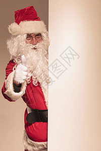 圣诞老人拿着一张空白面板把拇图片