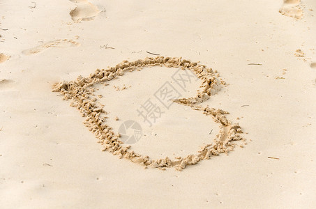 在沙滩上的黄沙中画的心图片