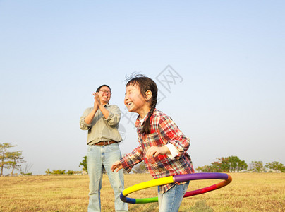 快乐的小女孩在户外玩呼啦圈图片