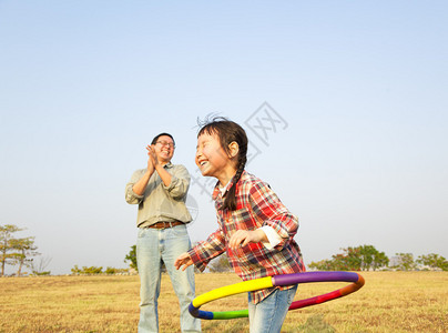 快乐的小女孩在户外玩呼啦圈图片