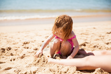 坐在沙滩上用沙子埋葬母亲脚图片