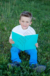 坐在草地上看书的小孩图片