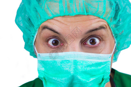 大眼睛戴着外科口罩和帽子的外科医生惊讶图片