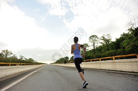 跑在路上的女赛跑运动员图片