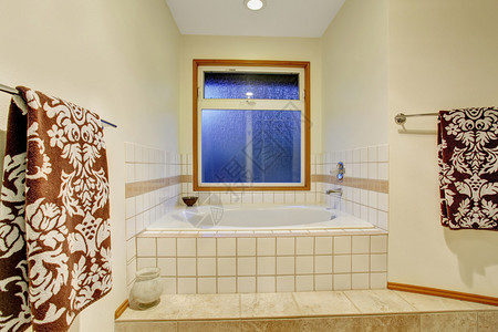 漂亮的主浴室带按摩浴缸和瓷砖地板图片
