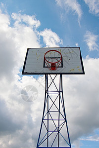 破旧的篮球架和背景中的蓝天背景图片