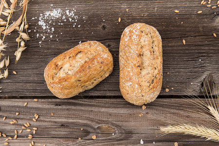 古朴的法式长棍面包和小麦放在一张老式木板桌上图片