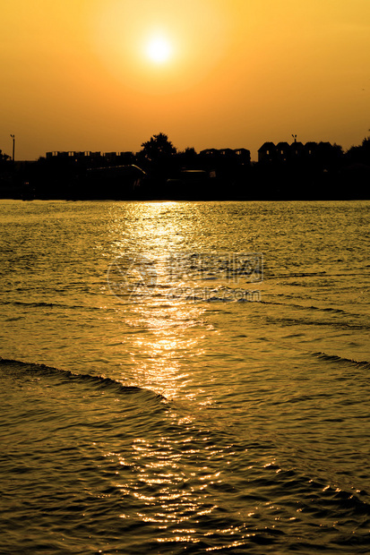 黄色夕阳下的大海和滩小镇图片