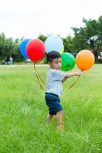 可爱的亚洲小男孩玩一堆气球图片