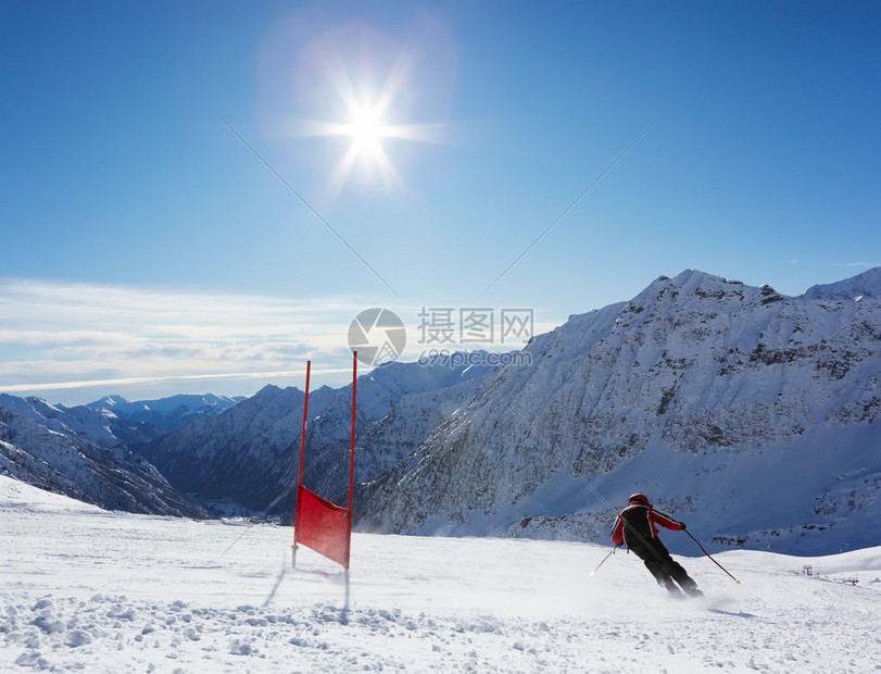 年轻的滑雪运动员在巨人Slalom课程上下坡图片