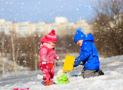 小男孩和女孩在冬天挖雪孩子背景图片