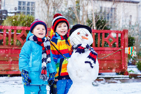 两个小兄弟姐妹男孩堆雪人图片