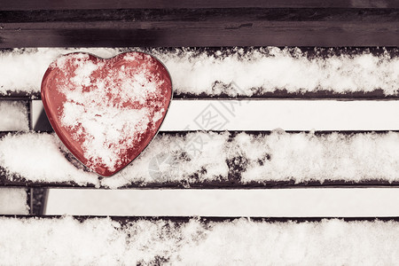 红心成形的锡箱在板凳上布满雪图片