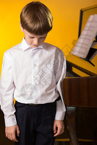年轻男孩弹钢琴弹奏乐谱图片